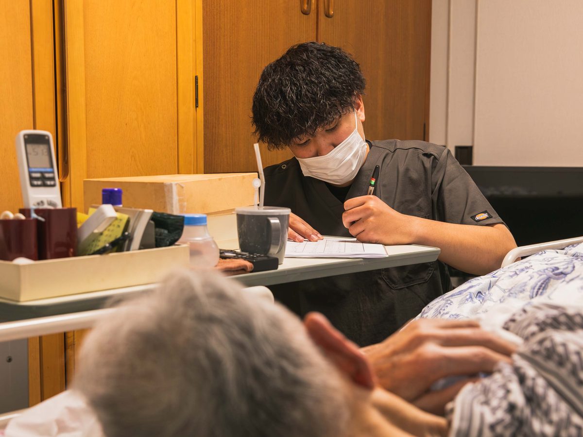 訪問先で記録を書くOGK訪問看護のスタッフ